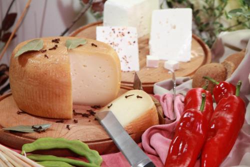 a table with cheese and vegetables on a cutting board at Dedalos Beach Hotel in Sfakaki