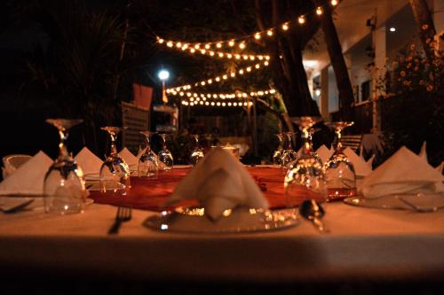 una mesa con gafas, servilletas y luces. en Island Front - Bangcogon Resort and Restaurant, en Oslob