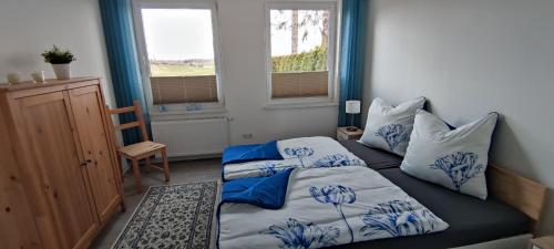 1 dormitorio con 2 camas con sábanas azules y blancas en FeWo Lieblingshof en Lieblingshof