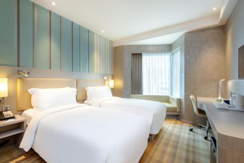 a hotel room with two beds and a desk at Holiday Inn Express Hong Kong Mongkok, an IHG Hotel in Hong Kong
