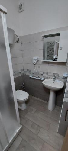 a bathroom with two sinks and a toilet and a mirror at Clausis in Parghelia