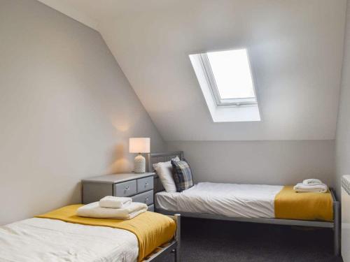 twee bedden in een kleine kamer met een raam bij Rural 3 Bedroom house, Newport - The Lifeboat in Porchfield