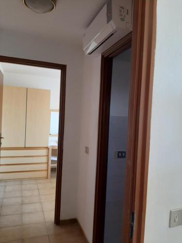 a hallway with a door leading into a room with a kitchen at Hotel Conca d'Oro in Stalettì