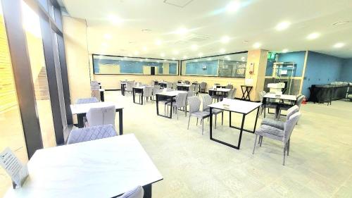 a dining room with tables and chairs in a restaurant at Sanbangsan Hotel-Formerly Primula Hotel in Seogwipo