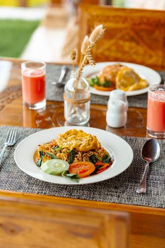 einen Tisch mit zwei Teller Essen auf einem Tisch in der Unterkunft Campuhan Sebatu Resort in Tegalalang