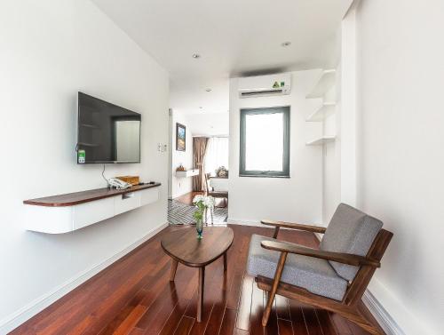 a living room with a table and a chair and a television at Ngan Ha 2 Apartments in Ho Chi Minh City