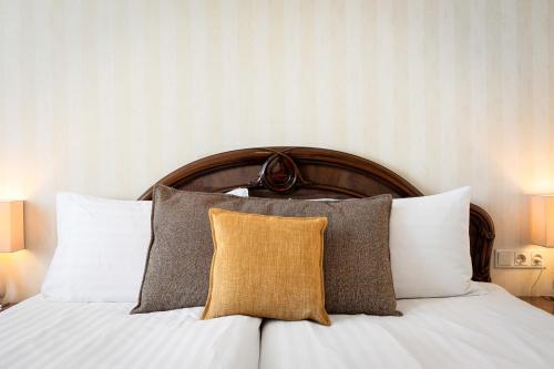 Bett mit einem Kopfteil aus Holz mit Kissen darauf in der Unterkunft Hotel Ísland - Comfort in Reykjavík