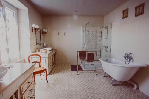 La BachellerieにあるChambre d'hôtes Au jardin de la Bachellerieのバスルーム(バスタブ、シャワー、シンク付)