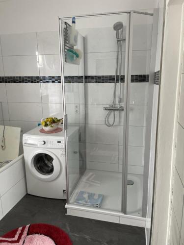 a shower with a washing machine in a bathroom at Ferienwohnung bunte Stadt an der Elde in Grabow