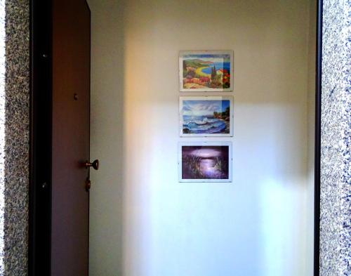 uma porta com três imagens na parede em Finestra sul mare em Palizzi