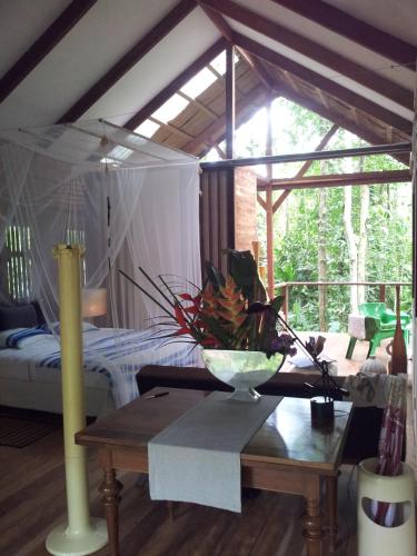 a bedroom with a bed and a table in a room at Mar Verde Lodge in Puerto Viejo