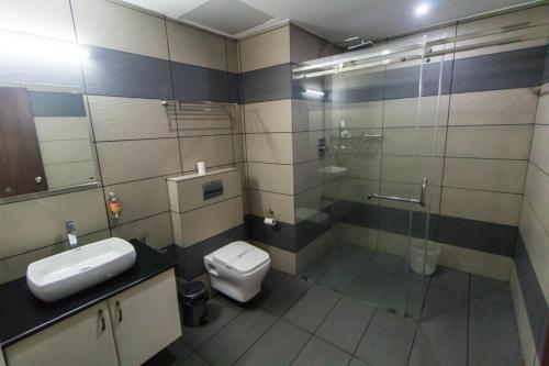 a bathroom with a toilet and a sink and a shower at Miracle Residency in Kizhake Chālakudi