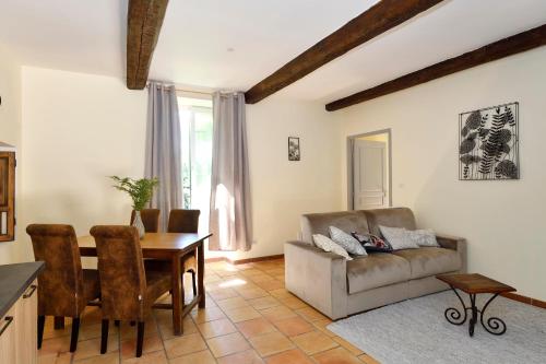 a living room with a table and a couch at Les Jardins de Falguière in Saint-Jean-du-Gard