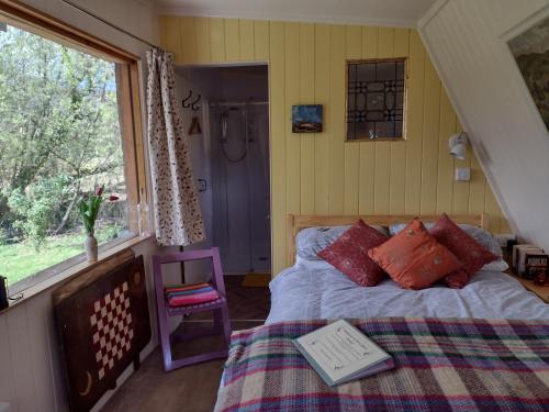 a bedroom with a bed and a window at The Cabins Conwy in Conwy