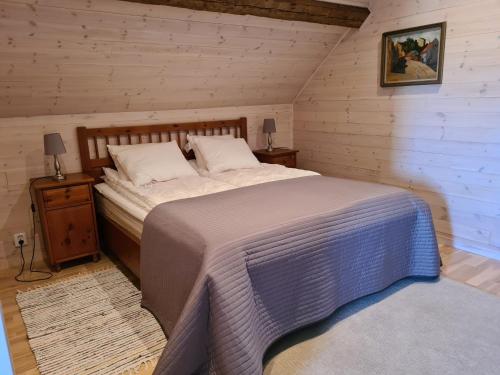 a bedroom with a large bed and a nightstand with a bed sidx sidx sidx at Augustas Bed & Breakfast in Falkenberg