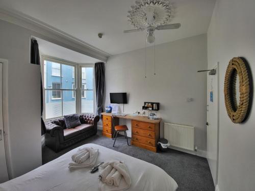 a bedroom with a bed and a desk and a chair at Ashby House in Tenby