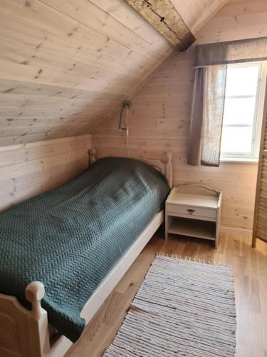 a bedroom with a green bed in a wooden cabin at Augustas Bed & Breakfast in Falkenberg
