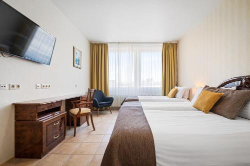 um quarto de hotel com duas camas e uma televisão de ecrã plano em Hotel Ísland - Comfort em Reykjavík