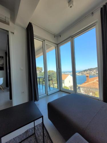 a bedroom with a bed and large windows at Design apartments 3&4 in Mali Lošinj