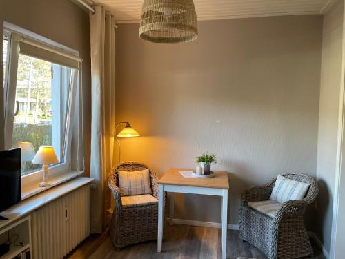 a room with a table and two chairs and a window at Strandallee Ferienwohnung in Timmendorfer Strand