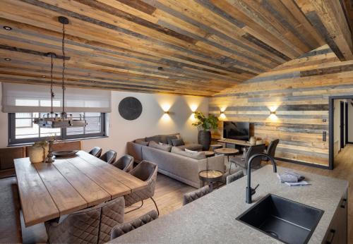 a kitchen and living room with a wooden ceiling at Nova Gosta Montafon NEU in Gaschurn