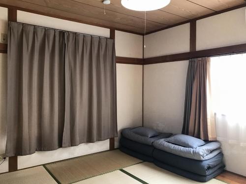 a living room with a blue couch in front of a window at Golden Mile Apartment in Amami