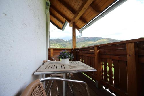 a wooden deck with a table and chairs on a balcony at Knirschenhof in Windischgarsten
