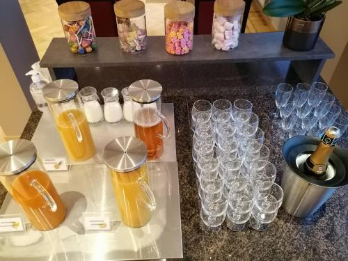 a table topped with glasses and bottles and drinks at Ambassador Hotel in De Panne