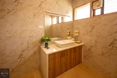 a bathroom with a sink and a mirror at Reunion Ocean Elite - Beach House in Udupi