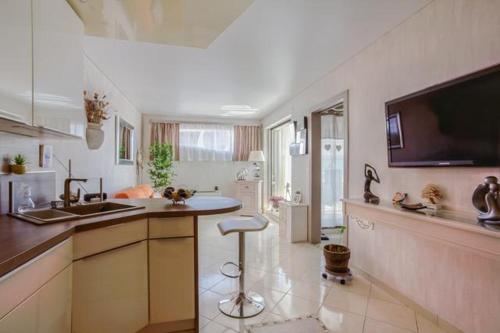 a kitchen with a sink and a bar stool in it at APPARTEMENT LA GRANDE MOTTE (34280) in La Grande-Motte