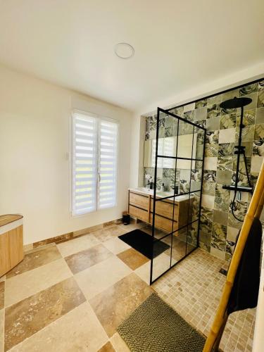 a bathroom with a shower and a tiled floor at résidence belle vue in Fontaine-le-Port