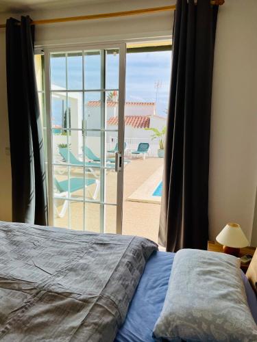 a bedroom with a bed and a view of a patio at Villa Jordi - Cala en Porter in Cala'n Porter