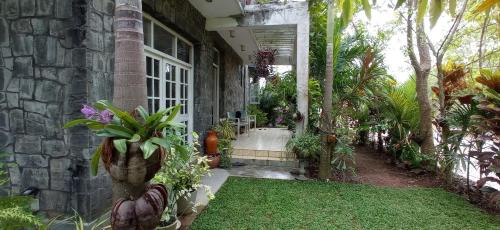 a stone house with a porch with a lawn at The Rock House in Katunayaka