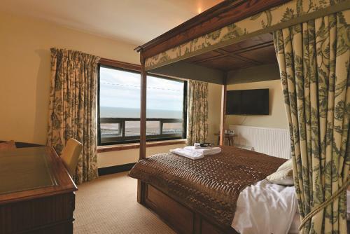 a hotel room with a bed and a large window at Bailey Ground Hotel in Seascale