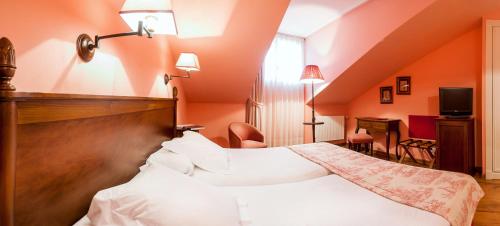 a hotel room with a bed with white sheets at Silken Spa La Hacienda De Don Juan in Llanes
