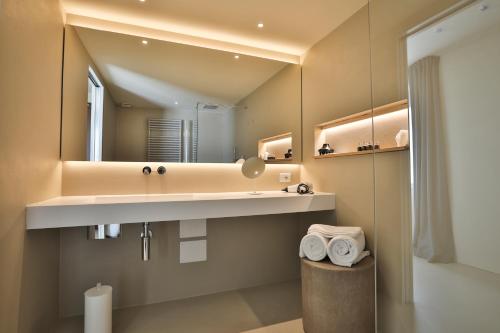 y baño con lavabo y espejo. en Mont Avic Resort & Wellness, en Champdepraz