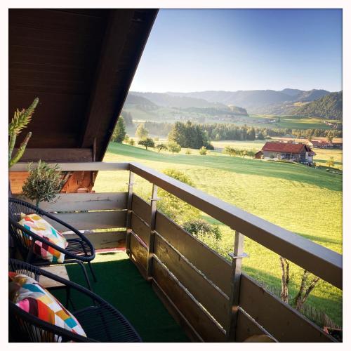 a balcony with a view of a green field at Oberstaufenblick.Allgäu in Stiefenhofen