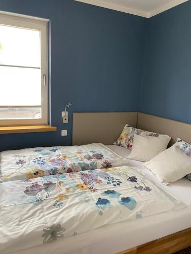 a bedroom with a bed with a floral comforter on it at MONzeit in Monschau