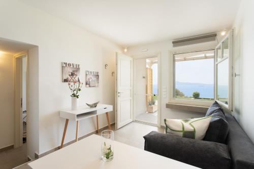 un soggiorno con divano e tavolo di Villa Itis - Elegant Ground Floor Suite with Terrace & Great View a Neapolis