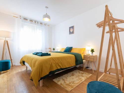 une chambre avec un lit avec une couverture jaune dans l'établissement LE STELLA - HYPERCENTRE GARAGE GRATUIT WiFi NETFLIX AMAZON PRIME PROCHE PARC TETE D'OR, à Villeurbanne