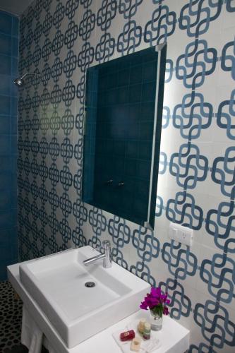 a bathroom with a white sink and a mirror at La Betulia Bed and Breakfast in Oaxaca City