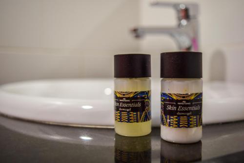 two bottles of sunscreen sitting on a bathroom counter at Sokaku i te Marreve GuestHouse in Gjirokastër