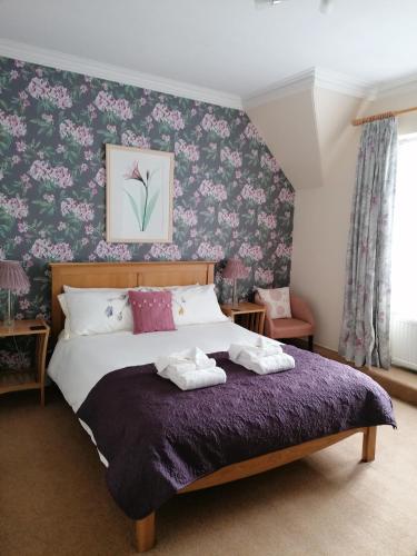 a bedroom with a large bed with a purple blanket at St Ann’s Guest House in Inverness