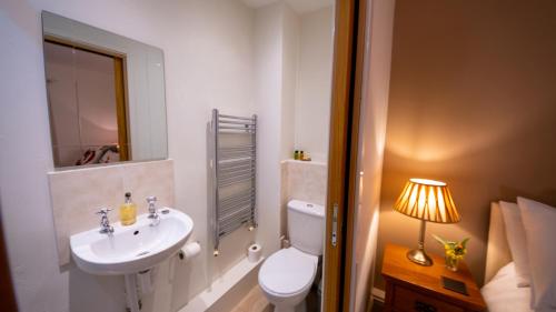 a bathroom with a sink and a toilet and a mirror at Rowrah Hall - The Old Dairy in Rowrah