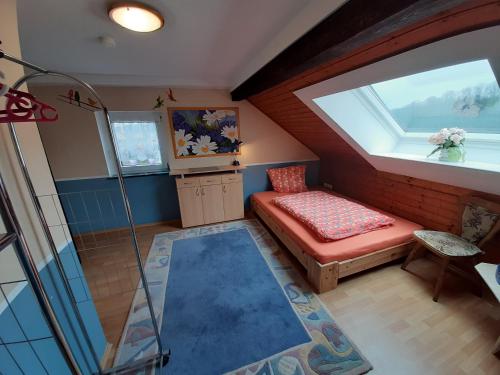 a attic room with a bench and a window at Ferienwohnung Dommes in Fuhrbach