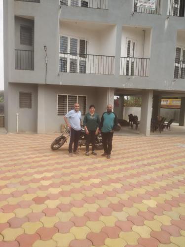 a group of three men standing in front of a building at Nature's Lap Homestay in Igatpuri