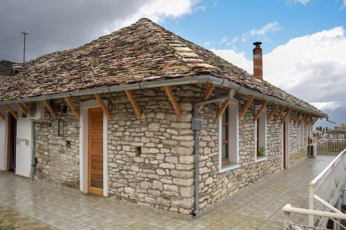 a small stone building with a roof at Sokaku i te Marreve GuestHouse in Gjirokastër