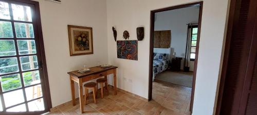 a room with a wooden table and a mirror at Villa Girassol in Ilhabela