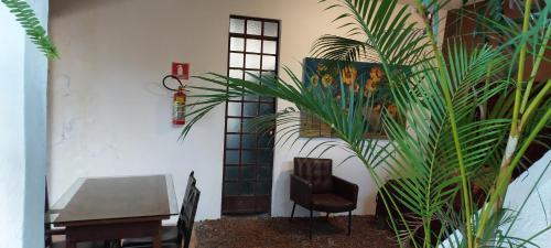 a room with a table and a chair and a plant at Villa Girassol in Ilhabela