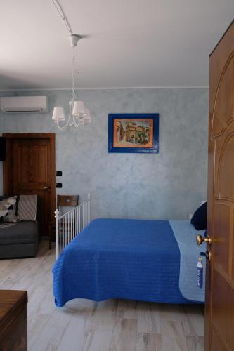 a bedroom with a blue bed and a couch at B&B VILLA IOLANDA un soggiorno in Relax vista Mare e Montagna in Fossacesia